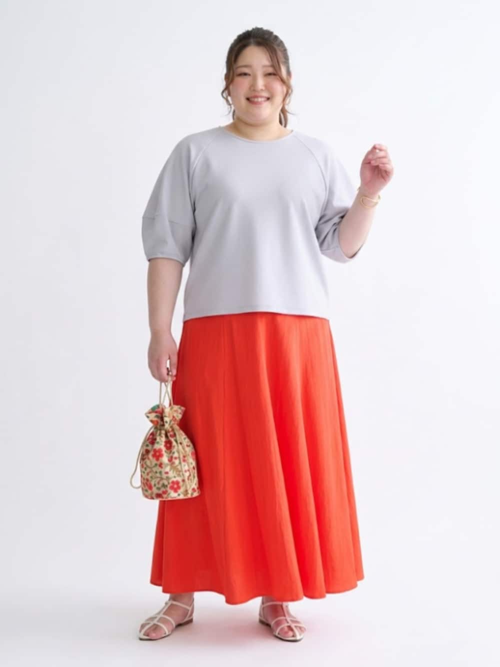 グレー系のTシャツ/カットソー、オレンジ系のスカートを着用したレディースの春コーディネートの2枚目の写真