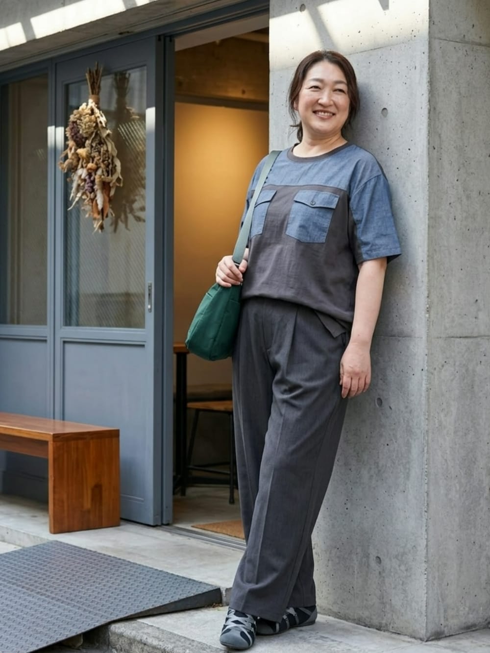 グレー系のTシャツ/カットソー、グレー系のパンツ、ブルー系のショルダーバッグを着用したレディースの夏コーディネートの2枚目の写真