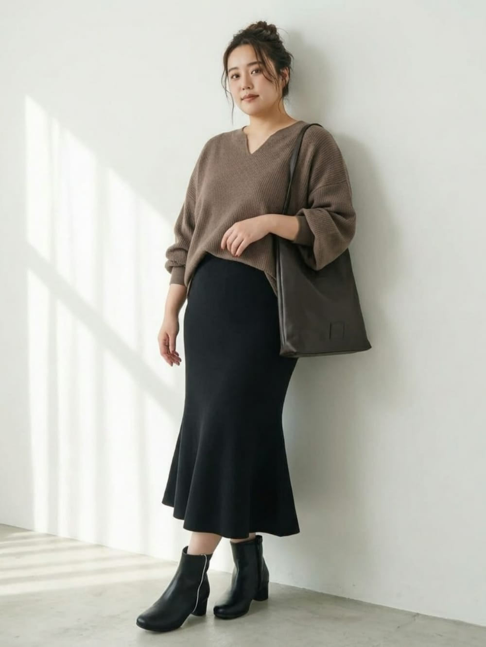 ブラック系のブーツ、ブラウン系のTシャツ/カットソー、ブラック系のスカートを着用したレディースの秋コーディネートの2枚目の写真