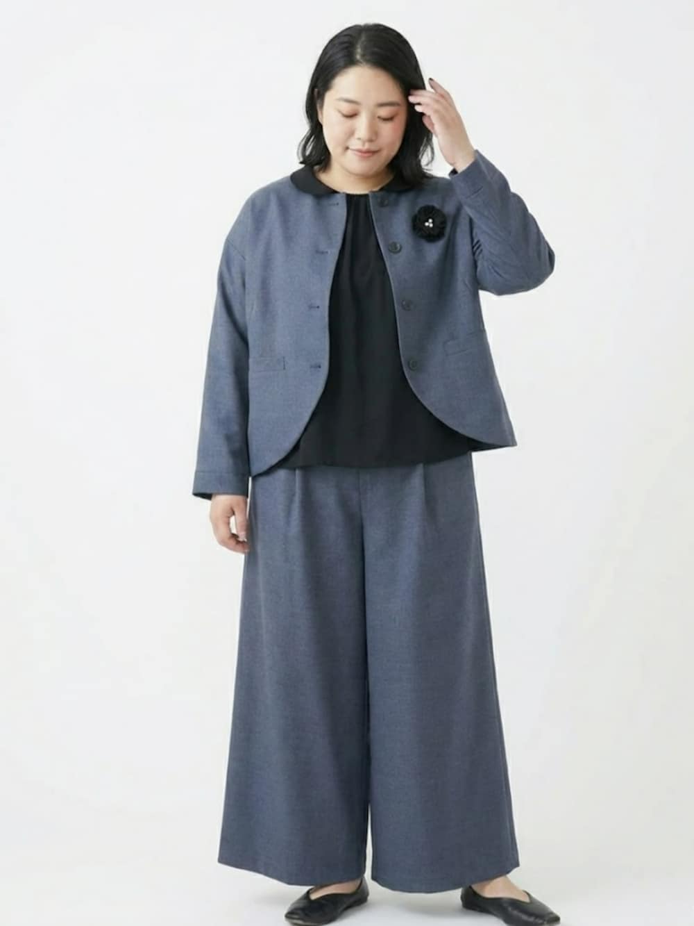 ブルー系のスーツセットを着用したレディースの冬コーディネートの2枚目の写真