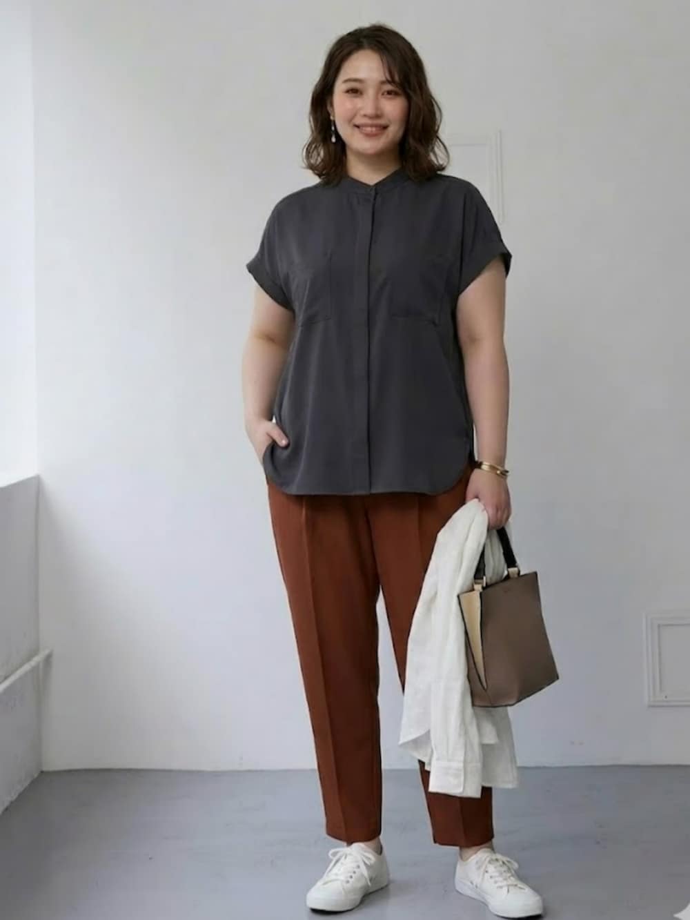 ホワイト系のシャツ/ブラウス、ブラウン系のパンツ、グレー系のシャツ/ブラウスを着用したレディースの春コーディネートの2枚目の写真