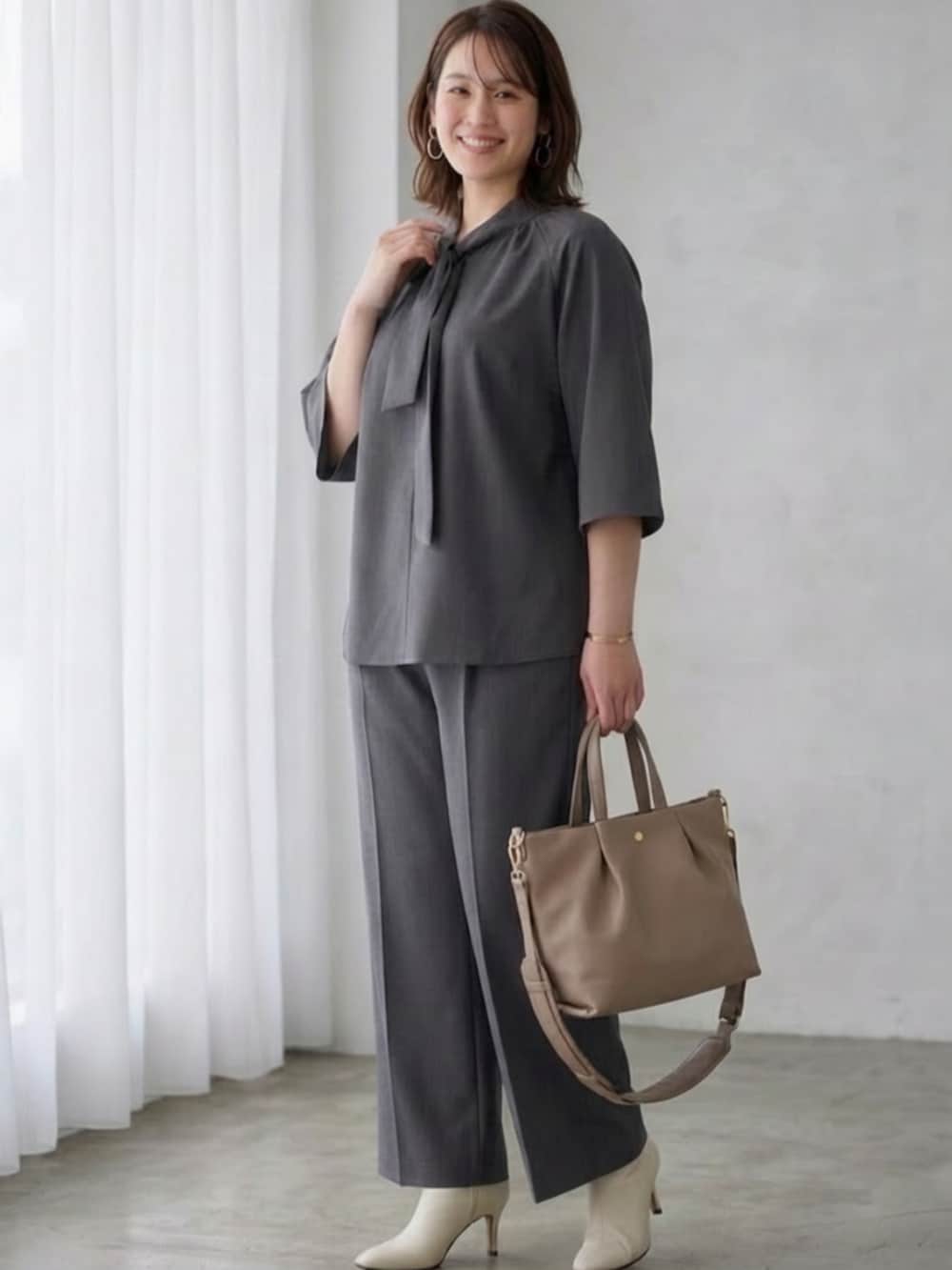 ベージュ系のショルダーバッグ、グレー系のシャツ/ブラウス、グレー系のその他パンツを着用したレディースの春コーディネートの3枚目の写真