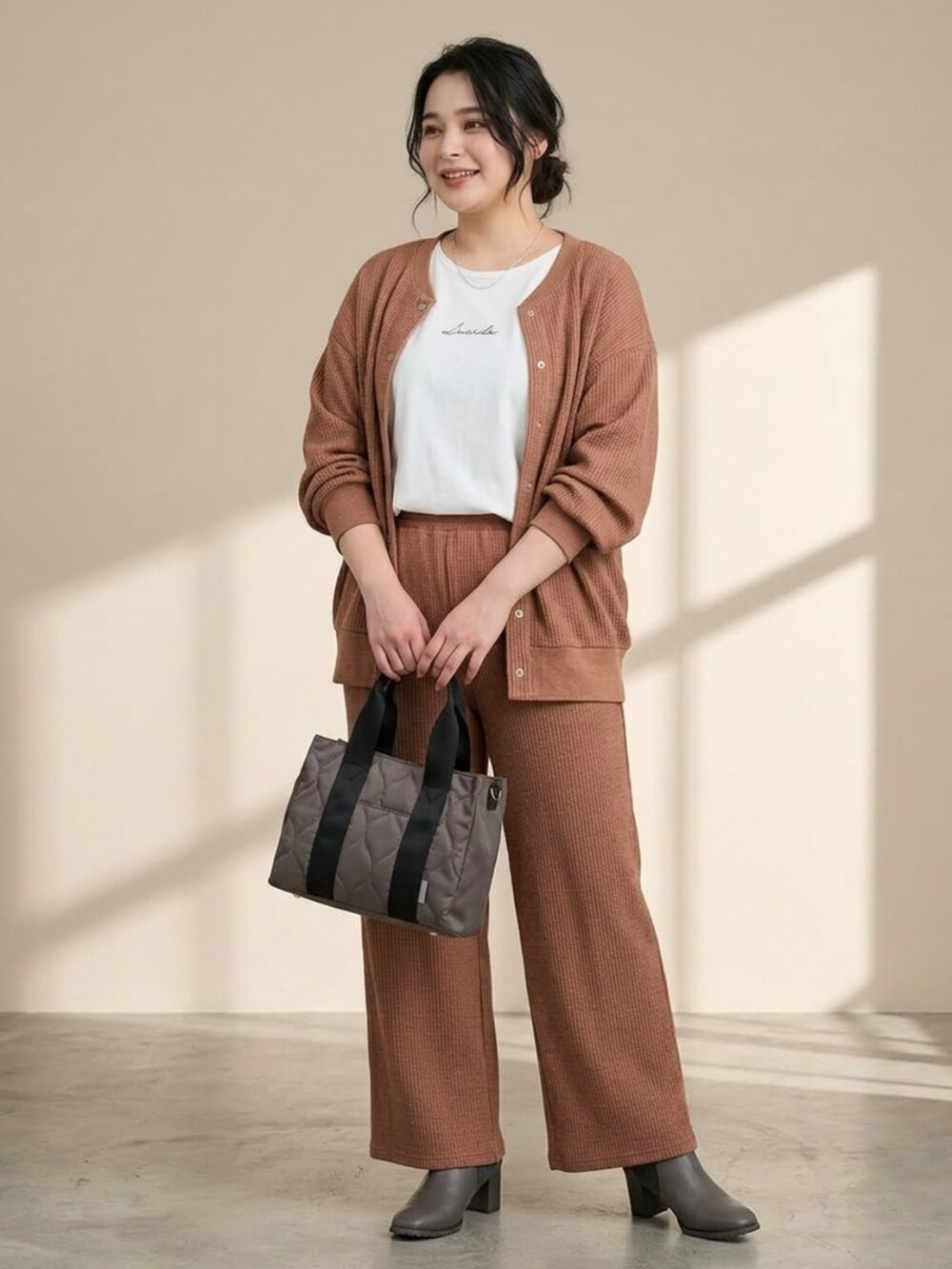ブラウン系のカーディガン/ボレロ、ブラウン系のパンツ、ホワイト系のTシャツ/カットソーを着用したレディースの秋コーディネートの3枚目の写真