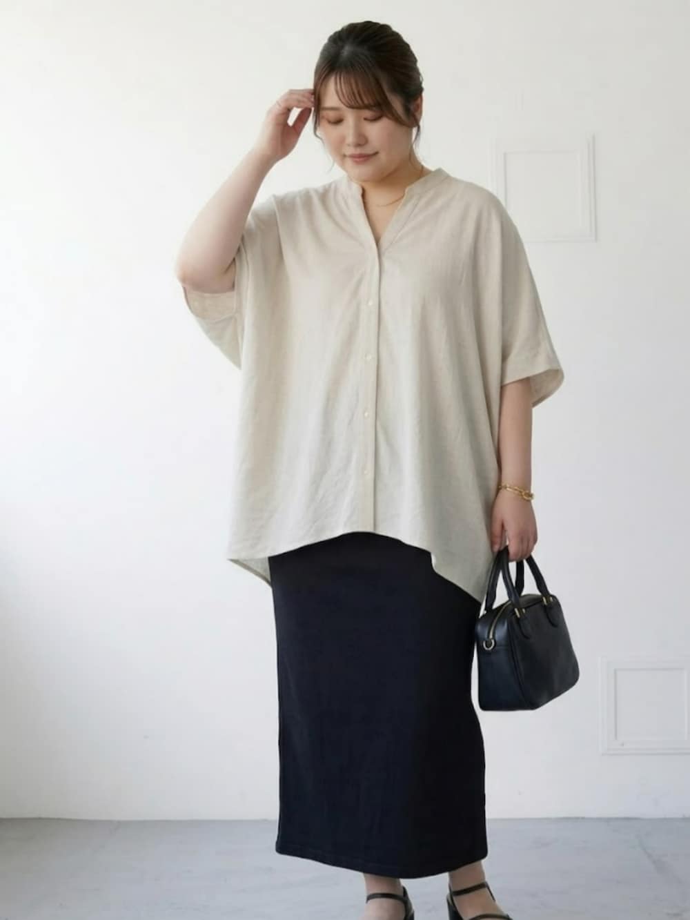 ベージュ系のシャツ/ブラウス、ブラック系のスカートを着用したレディースの春コーディネートの2枚目の写真