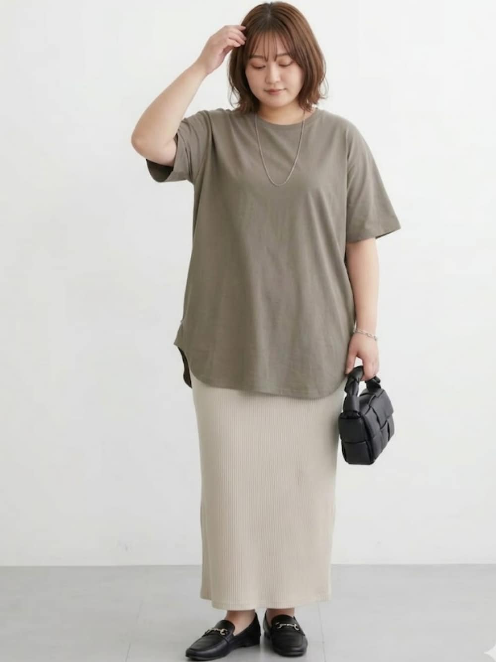 ベージュ系のスカート、ブラウン系のチュニックを着用したレディースの春コーディネートの2枚目の写真