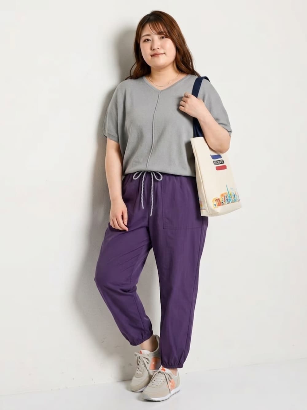 グレー系のニット/セーター、パープル系のパンツ、ブルー系のトートバッグを着用したレディースの夏コーディネートの2枚目の写真