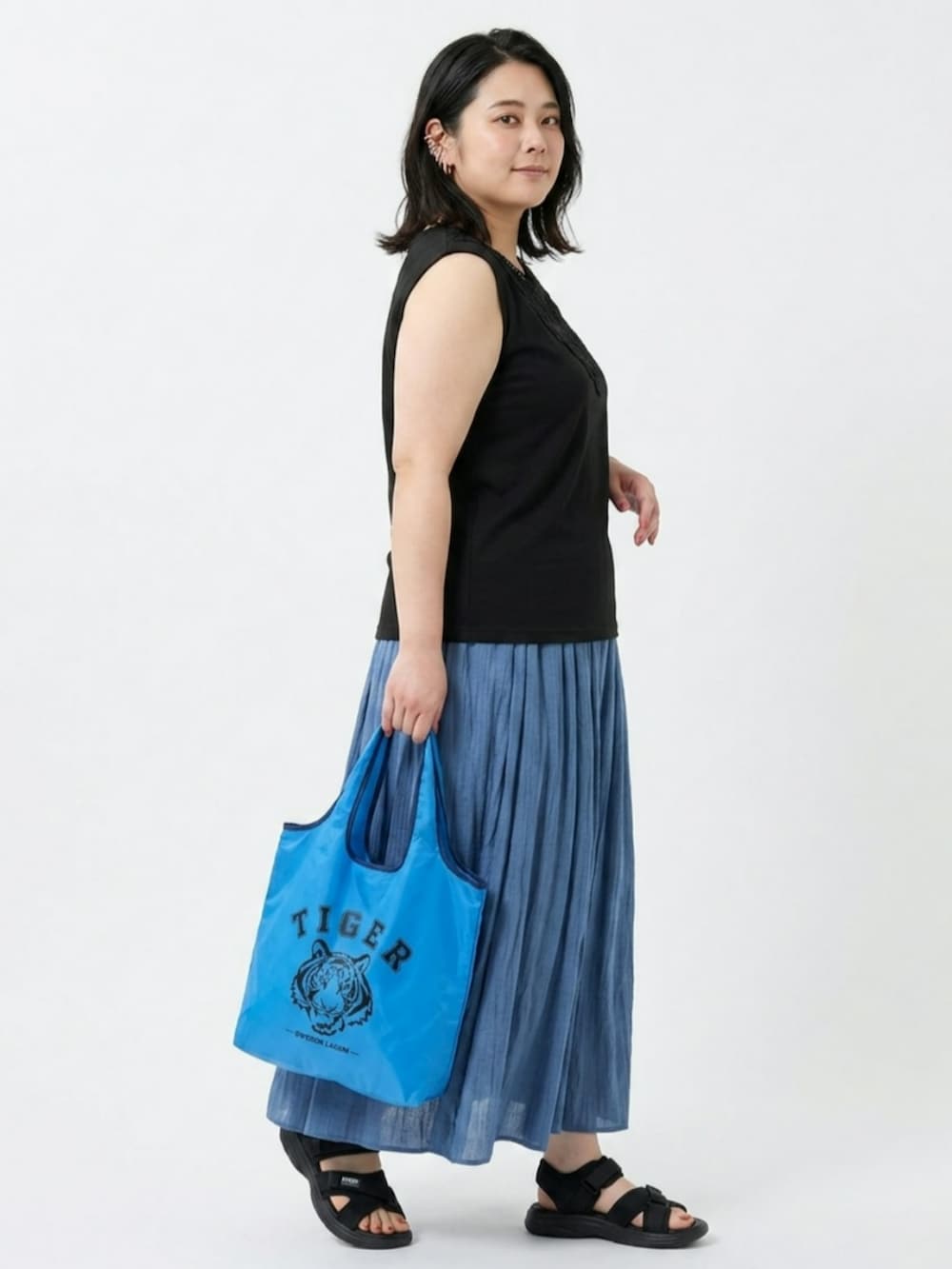 ブルー系のパンツ、ブルー系のエコバッグ/サブバッグ、ブラック系のキャミソールを着用したレディースの夏コーディネートの4枚目の写真