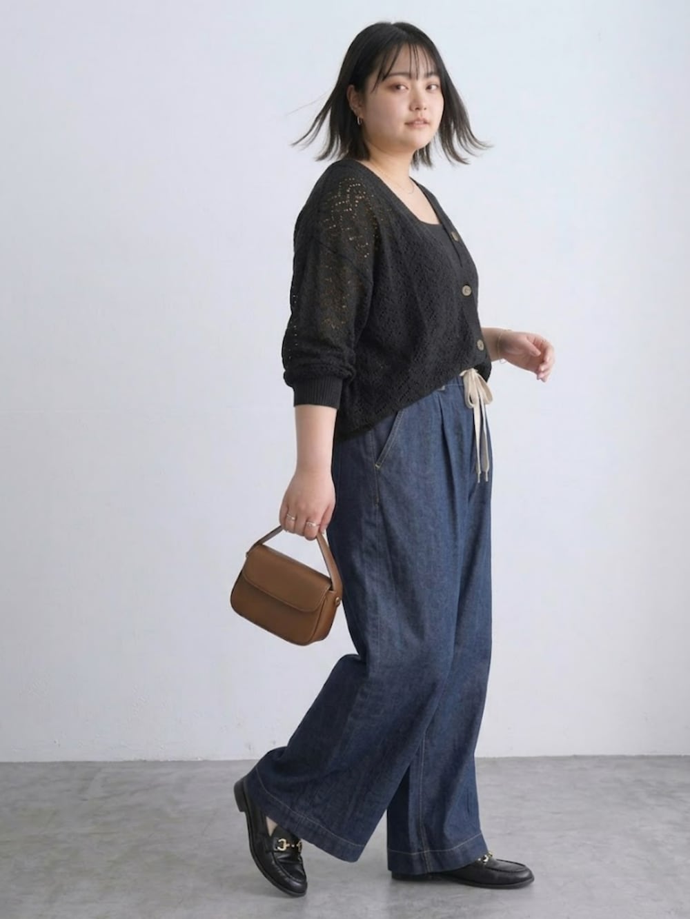 ブラック系のカーディガン/ボレロ、ブルー系のパンツ、ブラック系のキャミソールを着用したレディースの春コーディネートの2枚目の写真