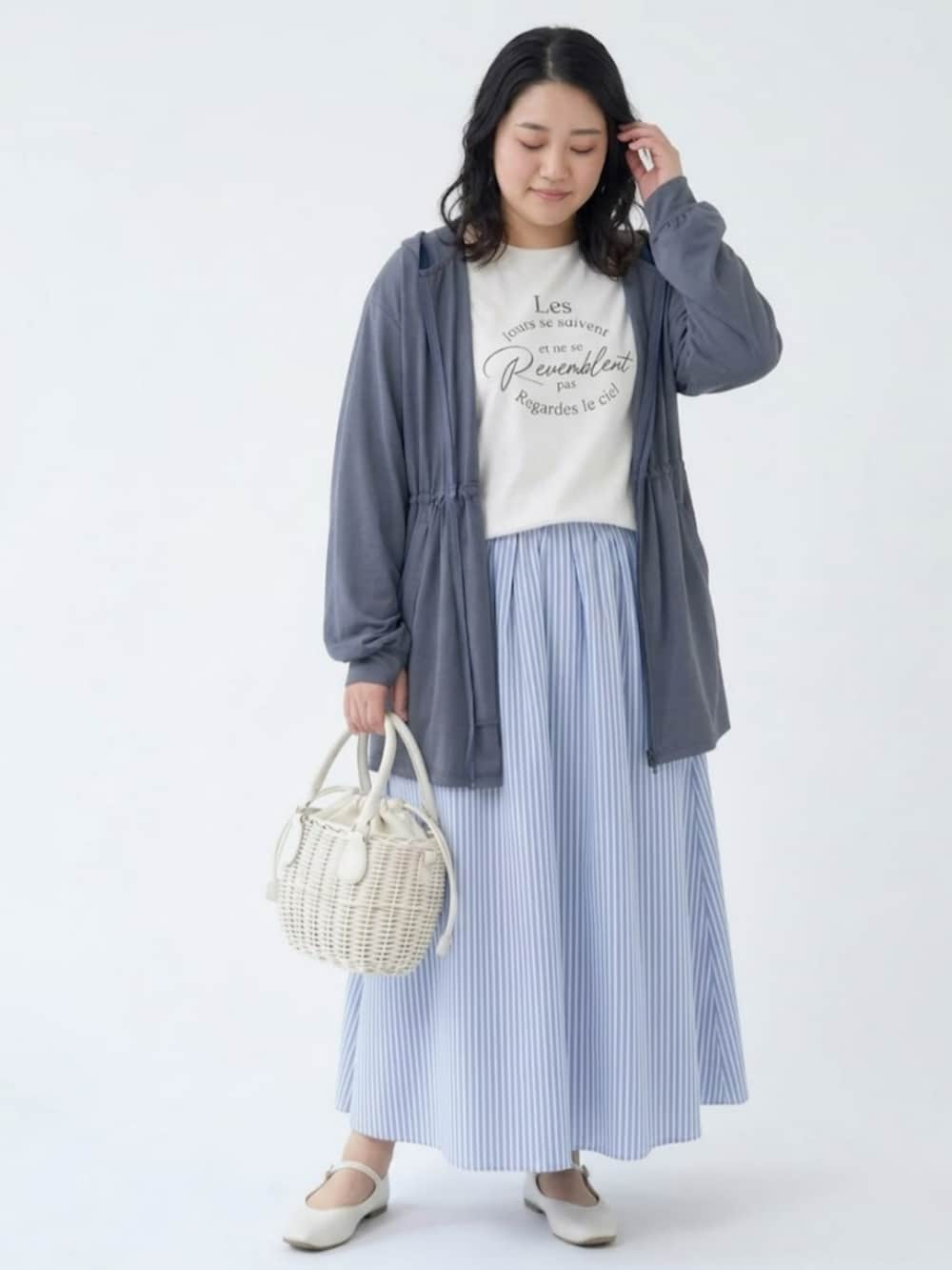 ホワイト系のパーカー、ホワイト系のチュニック、ブルー系のスカートを着用したレディースの春コーディネートの2枚目の写真