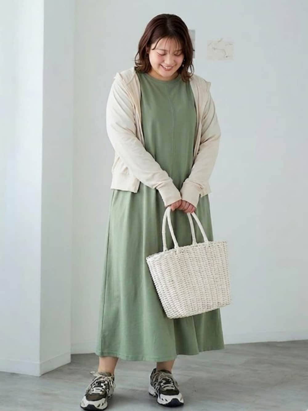グレー系のパーカー、グリーン系のワンピースを着用したレディースの春コーディネートの2枚目の写真