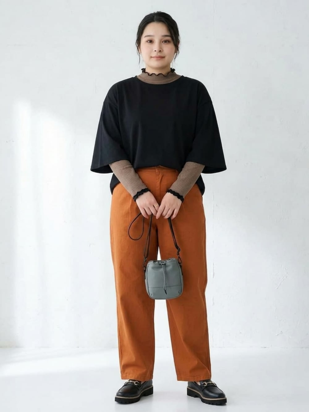 ブラウン系のTシャツ/カットソー、ブラック系のローファー、グレー系のショルダーバッグを着用したレディースの秋コーディネートの3枚目の写真