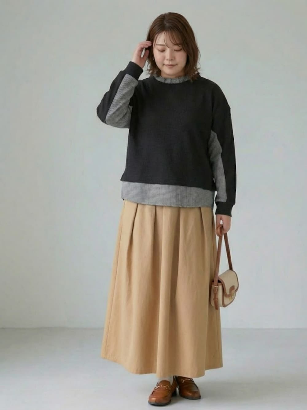 ベージュ系のスカート、ブラック系のTシャツ/カットソーを着用したレディースの冬コーディネートの2枚目の写真