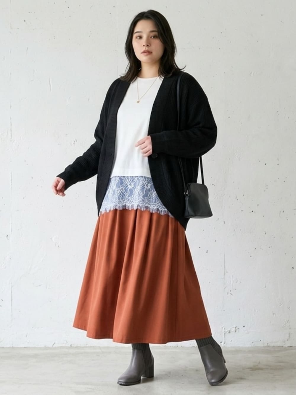 ホワイト系のTシャツ/カットソー、ブラック系のカーディガン/ボレロ、ブラウン系のスカートを着用したレディースの秋コーディネートの2枚目の写真
