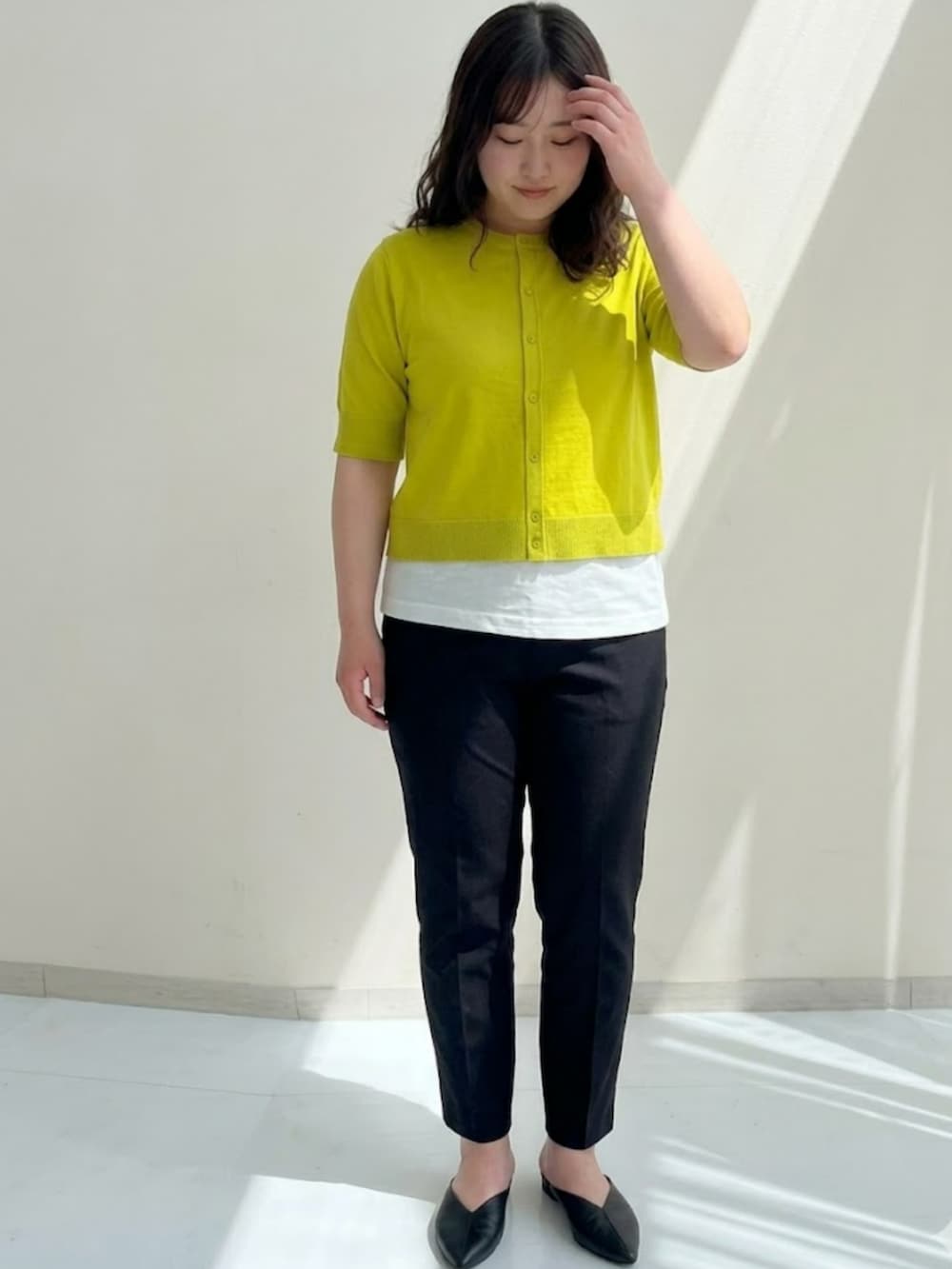 グレー系のキャミソール、イエロー系のカーディガン/ボレロ、ブルー系のパンツを着用したレディースの春コーディネートの2枚目の写真