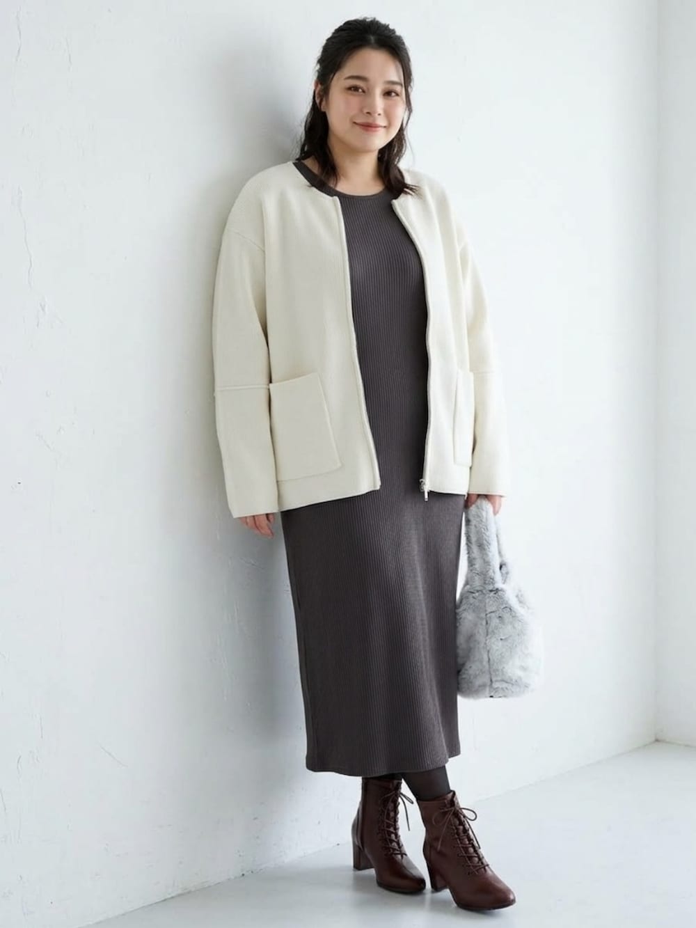 グレー系のワンピース、ベージュ系のジャケット/アウター、ブラウン系のブーツを着用したレディースの秋コーディネートの3枚目の写真