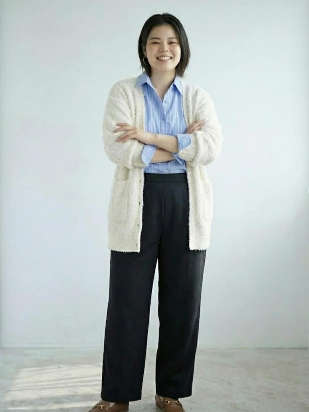 ブラック系のその他パンツ、ホワイト系のカーディガン/ボレロ、ブルー系のシャツ/ブラウスを着用したレディースの冬コーディネートの2枚目の写真