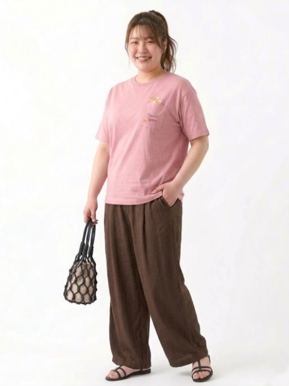 ブラウン系のパンツ、ピンク系のTシャツ/カットソーを着用したレディースの夏コーディネートの2枚目の写真
