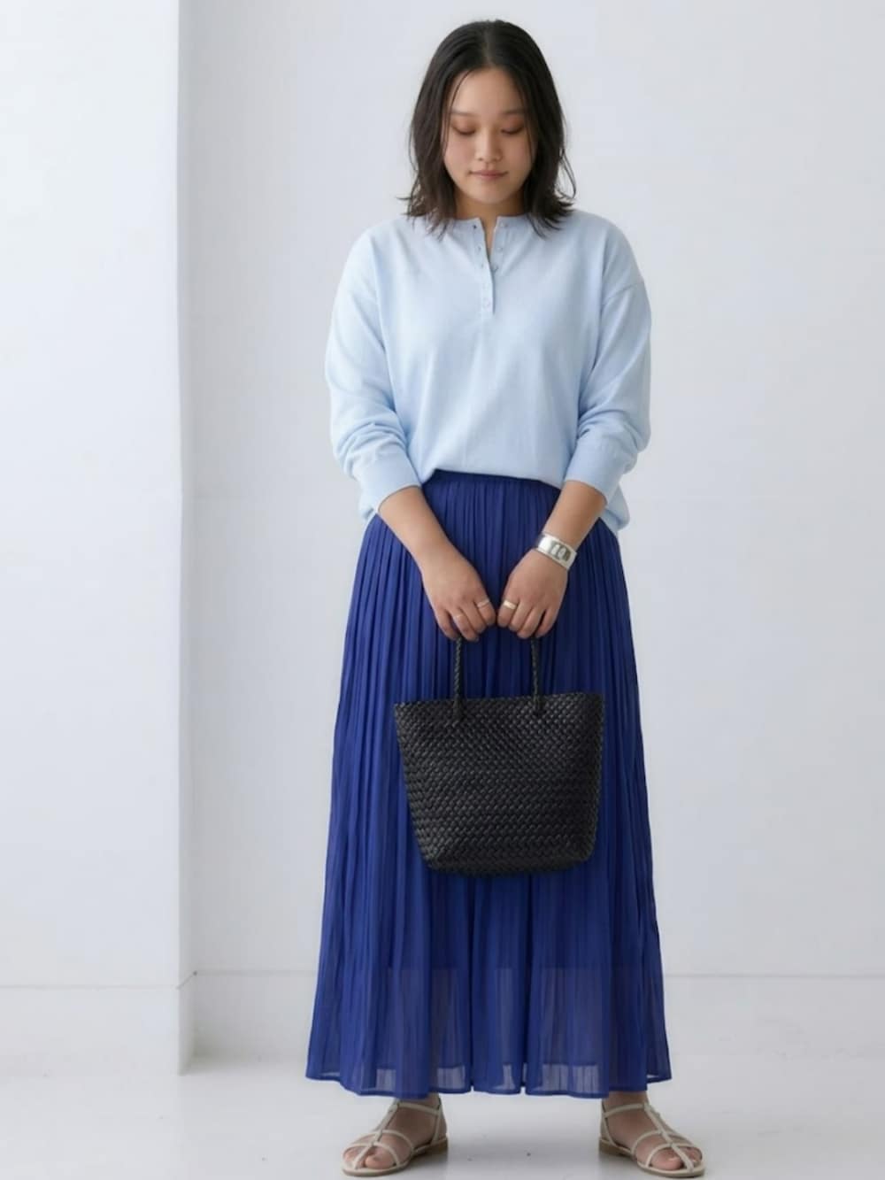 ブルー系のニット/セーター、ブルー系のスカートを着用したレディースの春コーディネートの2枚目の写真