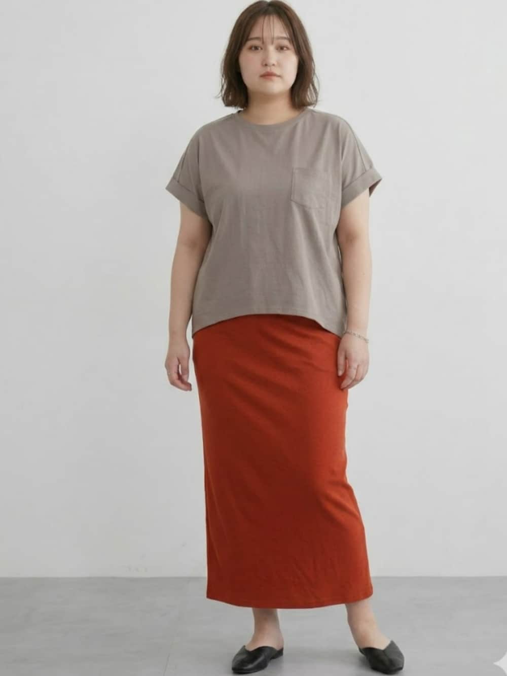 ブラウン系のTシャツ/カットソー、オレンジ系のスカートを着用したレディースの春コーディネートの2枚目の写真