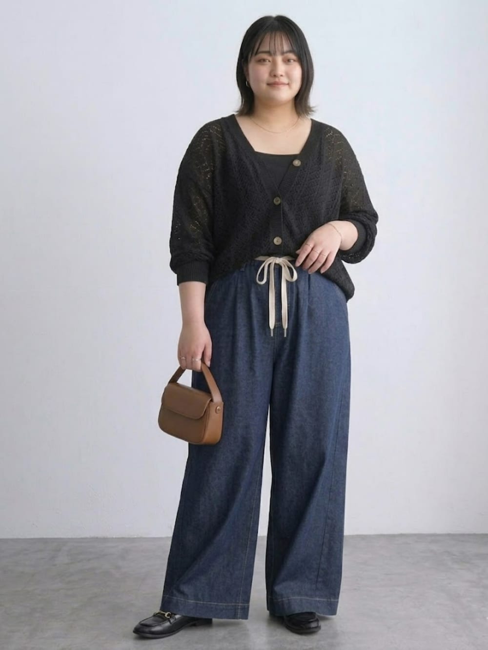 ブラック系のカーディガン/ボレロ、ブルー系のパンツ、ブラック系のキャミソールを着用したレディースの春コーディネートの3枚目の写真