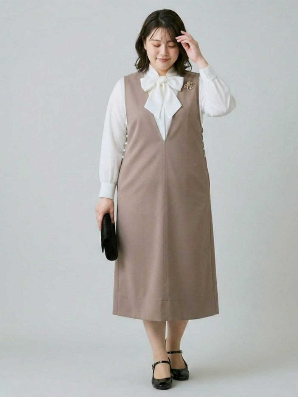 ブラウン系のスーツセットを着用したレディースの冬コーディネートの2枚目の写真