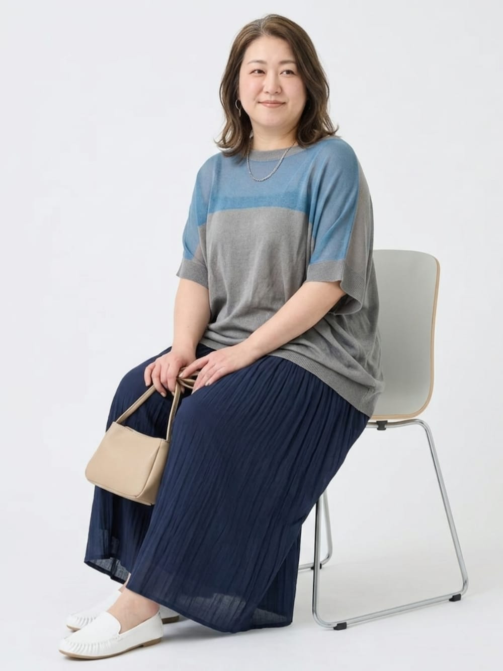 ベージュ系のパンツ、ホワイト系のバレエシューズ、ブルー系のニット/セーターを着用したレディースの夏コーディネートの2枚目の写真