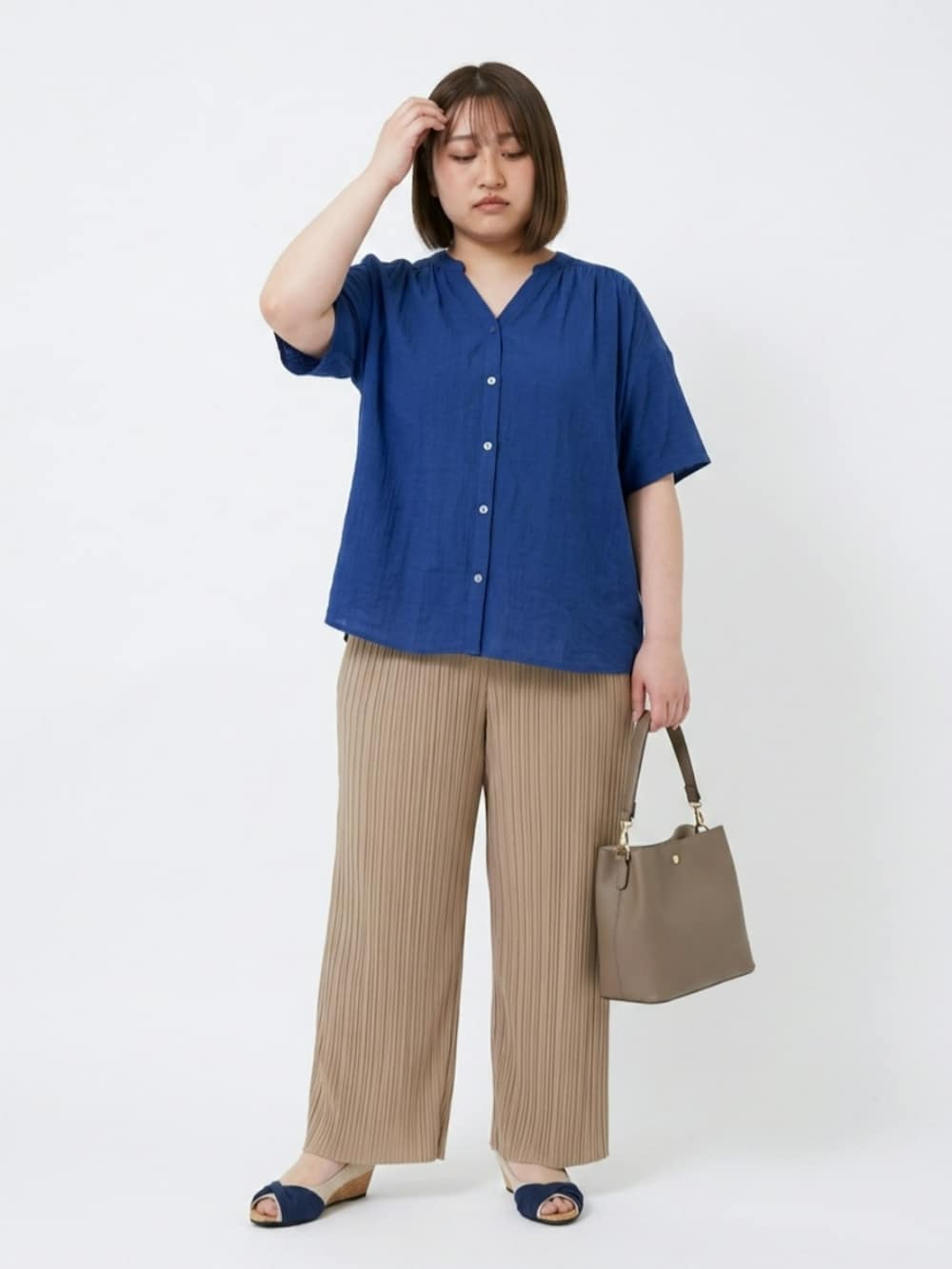 ブルー系のパンプス、グレー系のショルダーバッグ、ベージュ系のその他パンツを着用したレディースの夏コーディネートの2枚目の写真