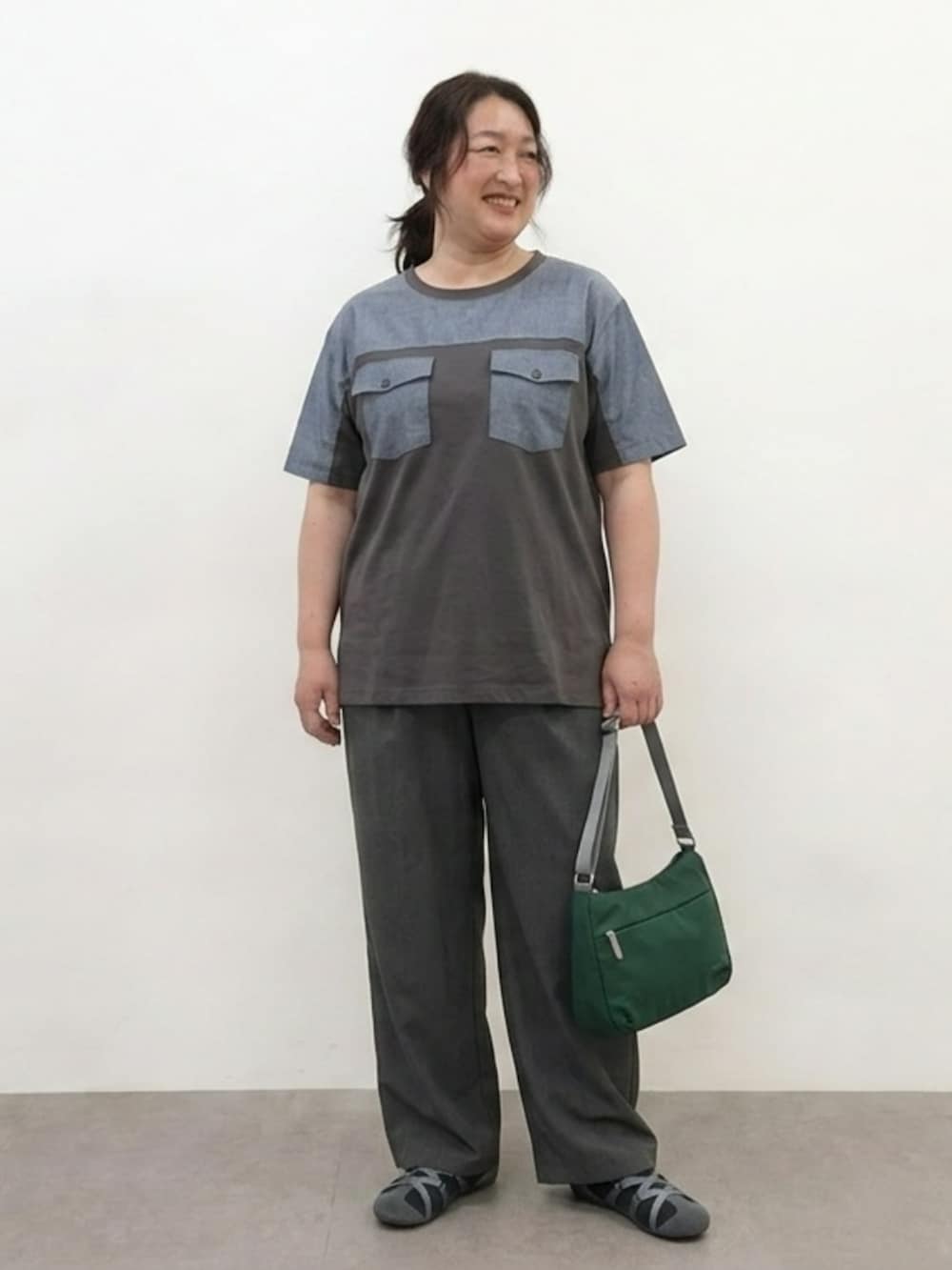 グレー系のTシャツ/カットソー、グレー系のパンツ、ブルー系のショルダーバッグを着用したレディースの夏コーディネートの4枚目の写真