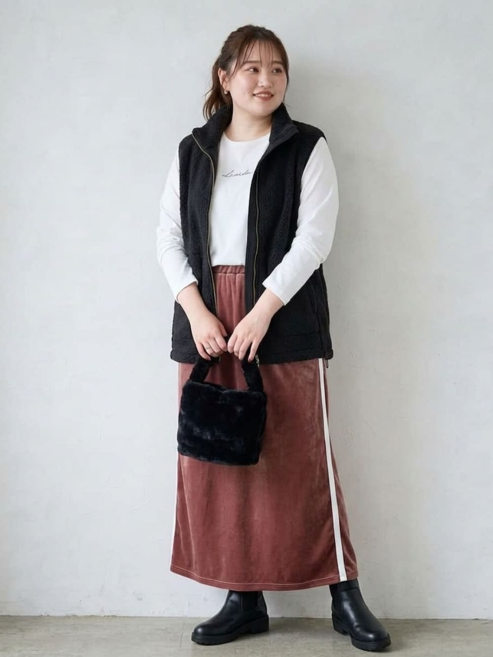 ホワイト系のTシャツ/カットソー、ブラック系のベスト、ピンク系のスカートを着用したレディースの秋コーディネートの3枚目の写真
