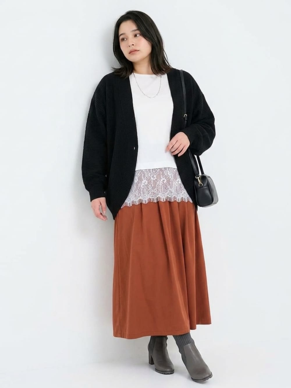 ホワイト系のTシャツ/カットソー、ブラック系のカーディガン/ボレロ、ブラウン系のスカートを着用したレディースの秋コーディネートの3枚目の写真