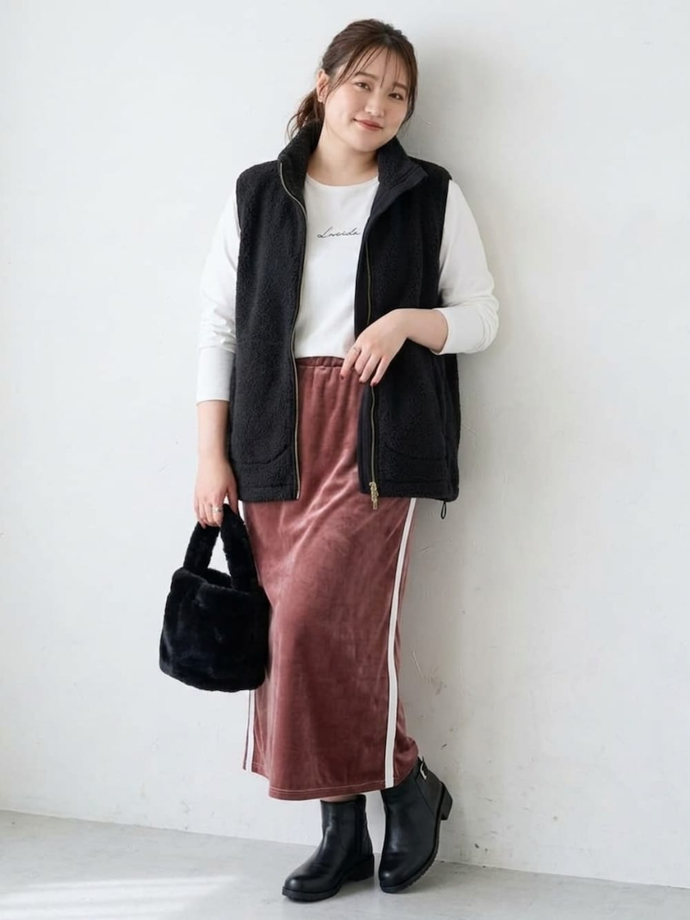 ホワイト系のTシャツ/カットソー、ブラック系のベスト、ピンク系のスカートを着用したレディースの秋コーディネートの2枚目の写真