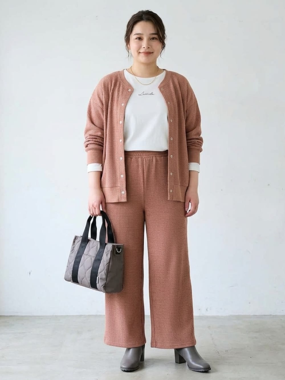 ブラウン系のカーディガン/ボレロ、ブラウン系のパンツ、ホワイト系のTシャツ/カットソーを着用したレディースの秋コーディネートの2枚目の写真