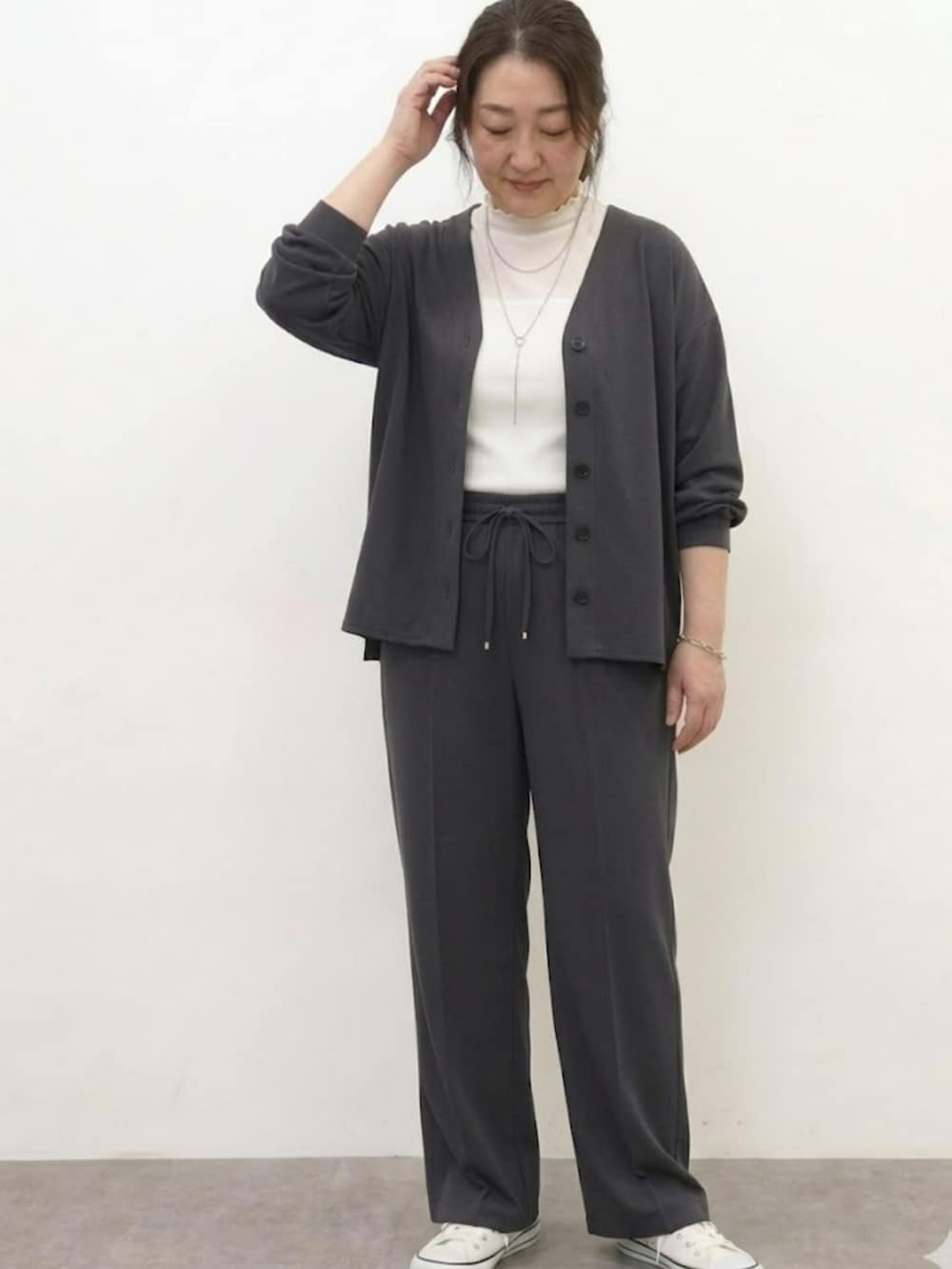 ホワイト系のTシャツ/カットソー、グレー系のカーディガン/ボレロ、グレー系のパンツを着用したレディースの春コーディネートの2枚目の写真