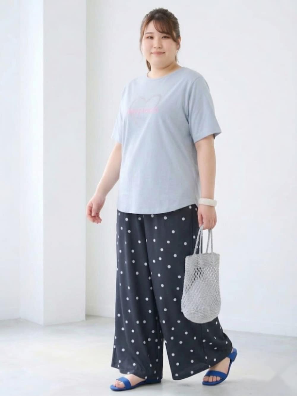グレー系のパンツ、ブルー系のTシャツ/カットソーを着用したレディースの春コーディネートの2枚目の写真
