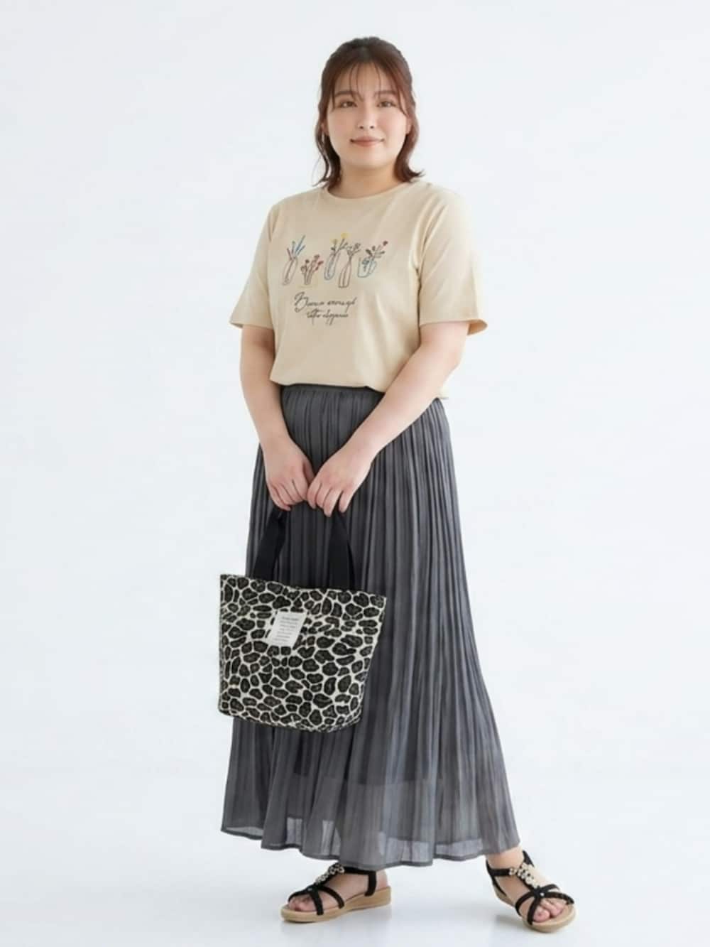 ベージュ系のチュニック、グレー系のスカート、ホワイト系のトートバッグを着用したレディースの夏コーディネートの3枚目の写真