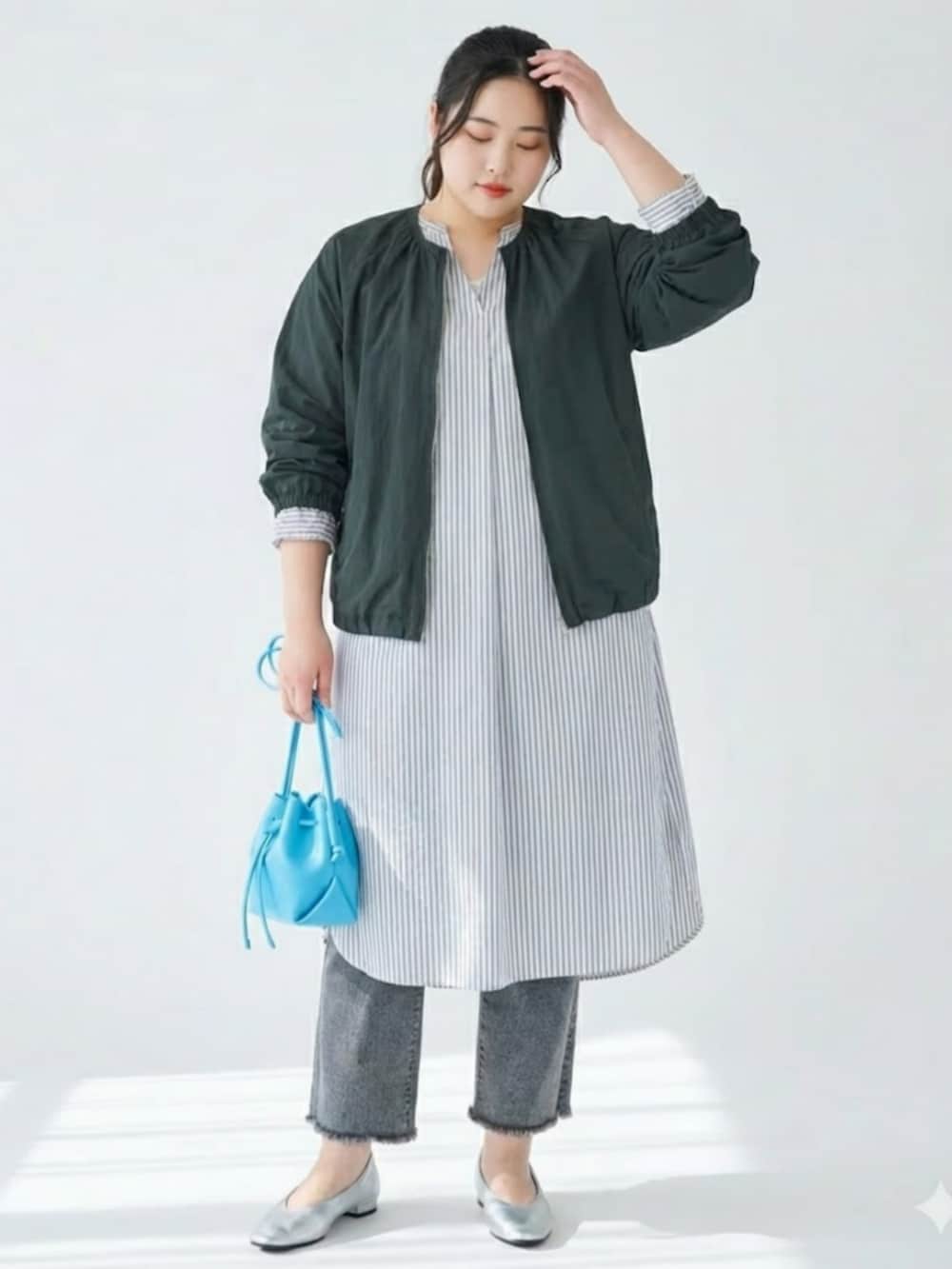 ホワイト系のワンピース、グレー系のデニムパンツ、ブラック系のジャケット/アウターを着用したレディースの冬コーディネートの2枚目の写真