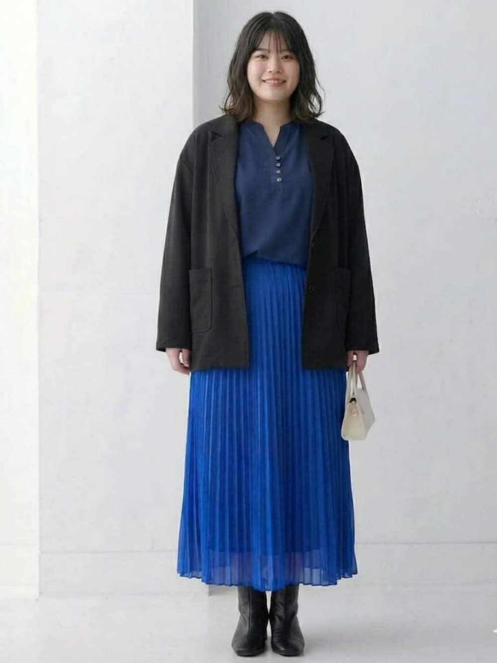 ブルー系のスカート、ブルー系のTシャツ/カットソー、ブラック系のジャケット/アウターを着用したレディースの冬コーディネートの2枚目の写真