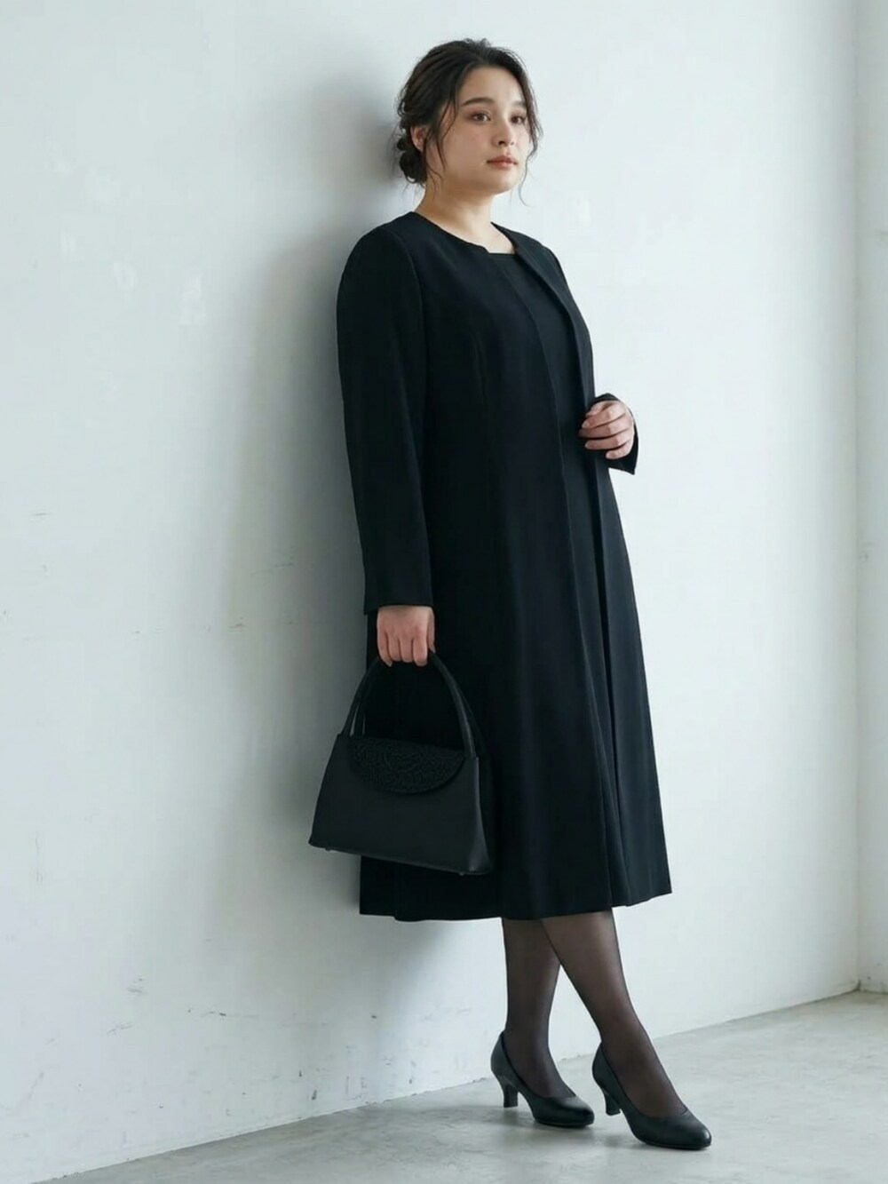 ブラック系のパンプス、ブラック系のバッグ、ブラック系のフォーマルスーツ/小物を着用したレディースの秋コーディネートの4枚目の写真
