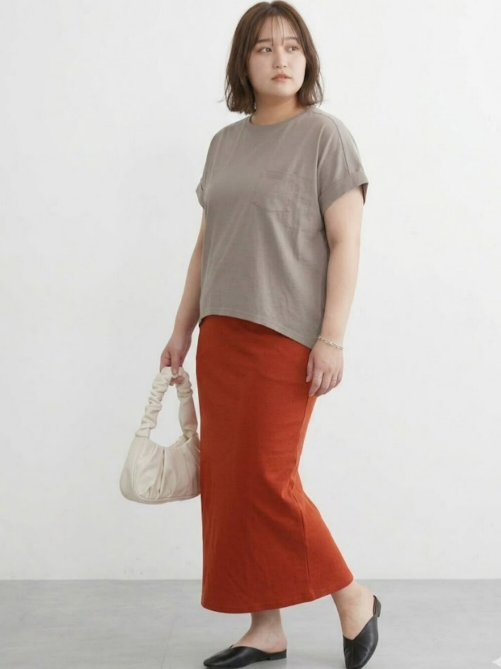 ブラウン系のTシャツ/カットソー、オレンジ系のスカートを着用したレディースの春コーディネートの3枚目の写真