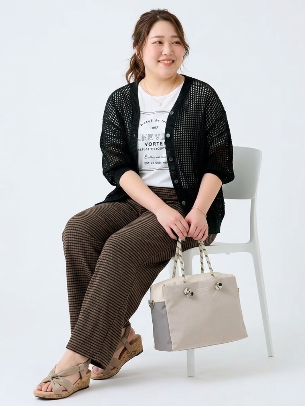 ホワイト系のTシャツ/カットソー、ブラック系のカーディガン/ボレロ、グレー系のトートバッグを着用したレディースの夏コーディネートの2枚目の写真