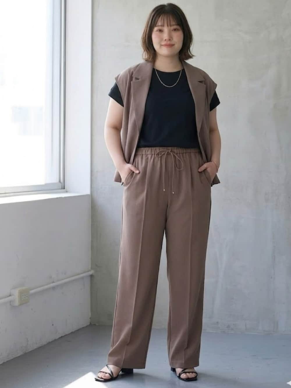 ベージュ系のスーツセット、ブラウン系のパンツ、ブラック系のTシャツ/カットソーを着用したレディースの春コーディネートの3枚目の写真