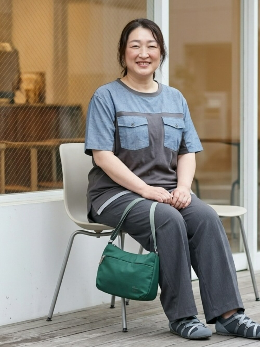 グレー系のTシャツ/カットソー、グレー系のパンツ、ブルー系のショルダーバッグを着用したレディースの夏コーディネートの3枚目の写真