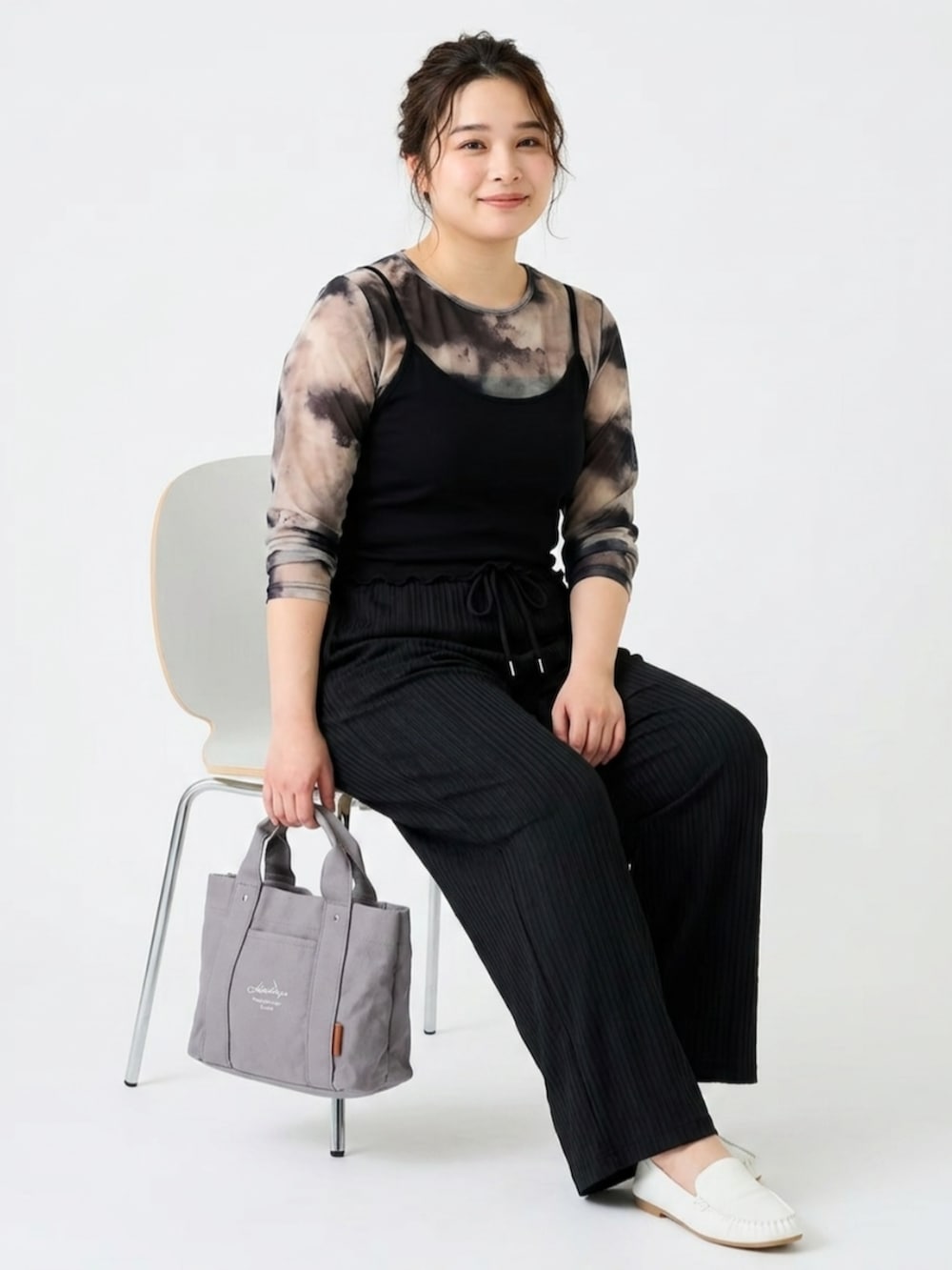 ブラック系のパンツ、グレー系のトートバッグ、ホワイト系のバレエシューズを着用したレディースの夏コーディネートの2枚目の写真