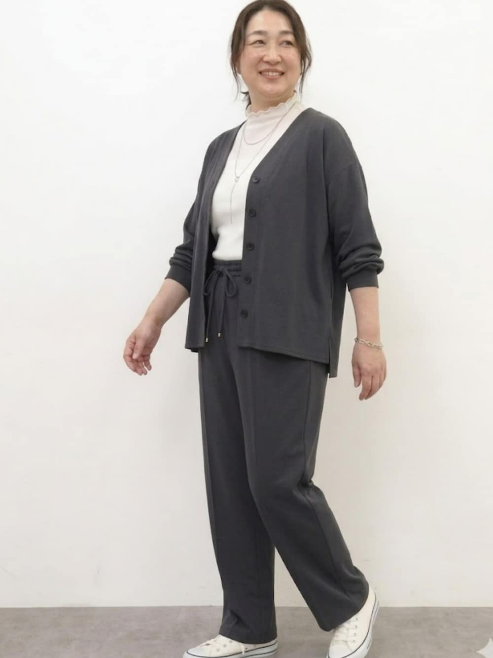 ホワイト系のTシャツ/カットソー、グレー系のカーディガン/ボレロ、グレー系のパンツを着用したレディースの春コーディネートの3枚目の写真