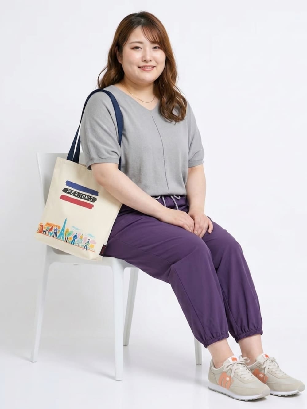 グレー系のニット/セーター、パープル系のパンツ、ブルー系のトートバッグを着用したレディースの夏コーディネートの3枚目の写真