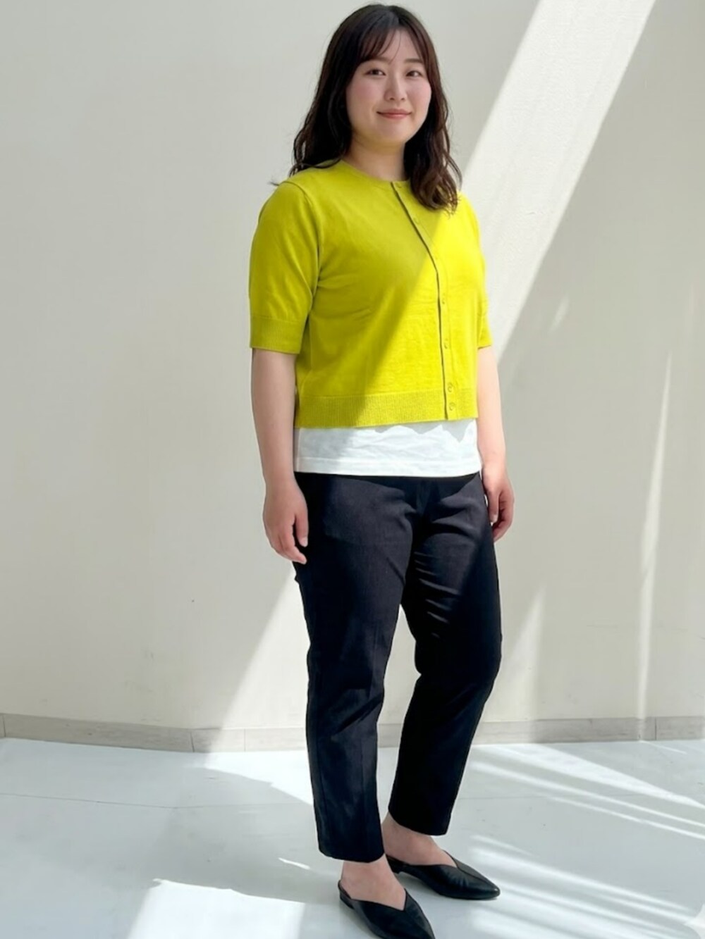 グレー系のキャミソール、イエロー系のカーディガン/ボレロ、ブルー系のパンツを着用したレディースの春コーディネートの3枚目の写真