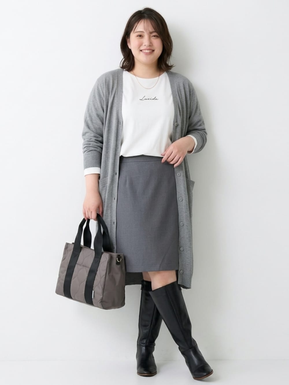 グレー系のトートバッグ、ホワイト系のTシャツ/カットソー、グレー系のカーディガン/ボレロを着用したレディースの秋コーディネートの2枚目の写真
