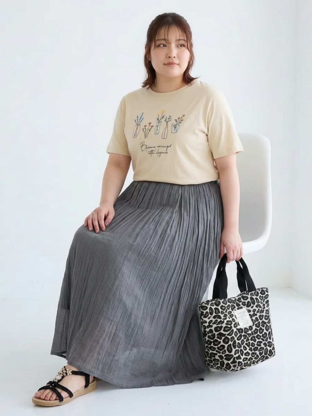 ベージュ系のチュニック、グレー系のスカート、ホワイト系のトートバッグを着用したレディースの夏コーディネートの2枚目の写真