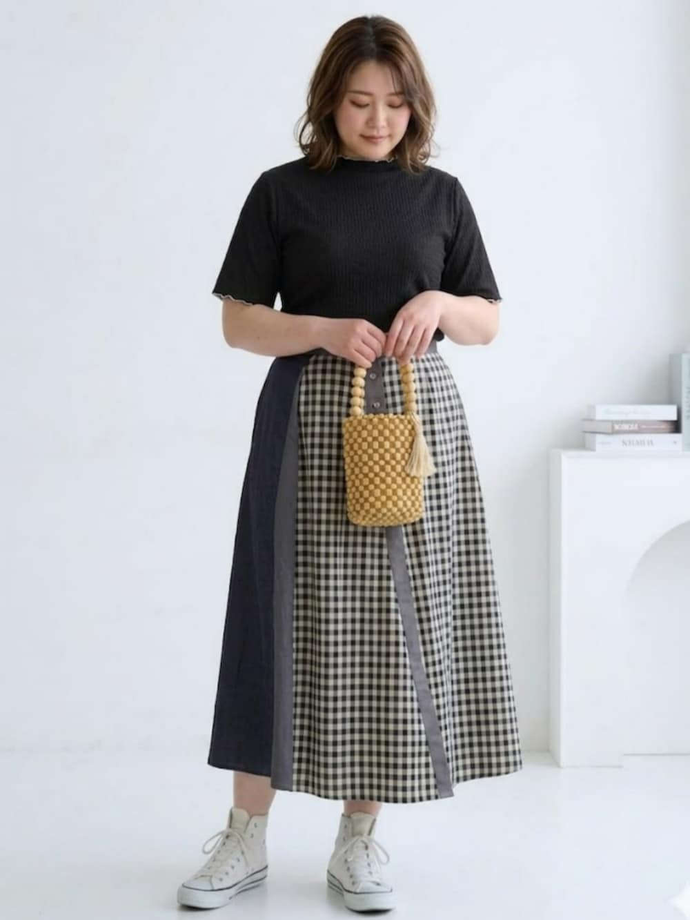 ブラック系のTシャツ/カットソー、ブラック系のスカート、グレー系の手袋を着用したレディースの春コーディネートの2枚目の写真