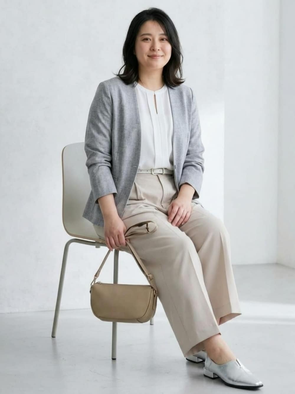 シルバー系のパンプス、グレー系のジャケット/アウター、ベージュ系のスラックスを着用したレディースの秋コーディネートの2枚目の写真